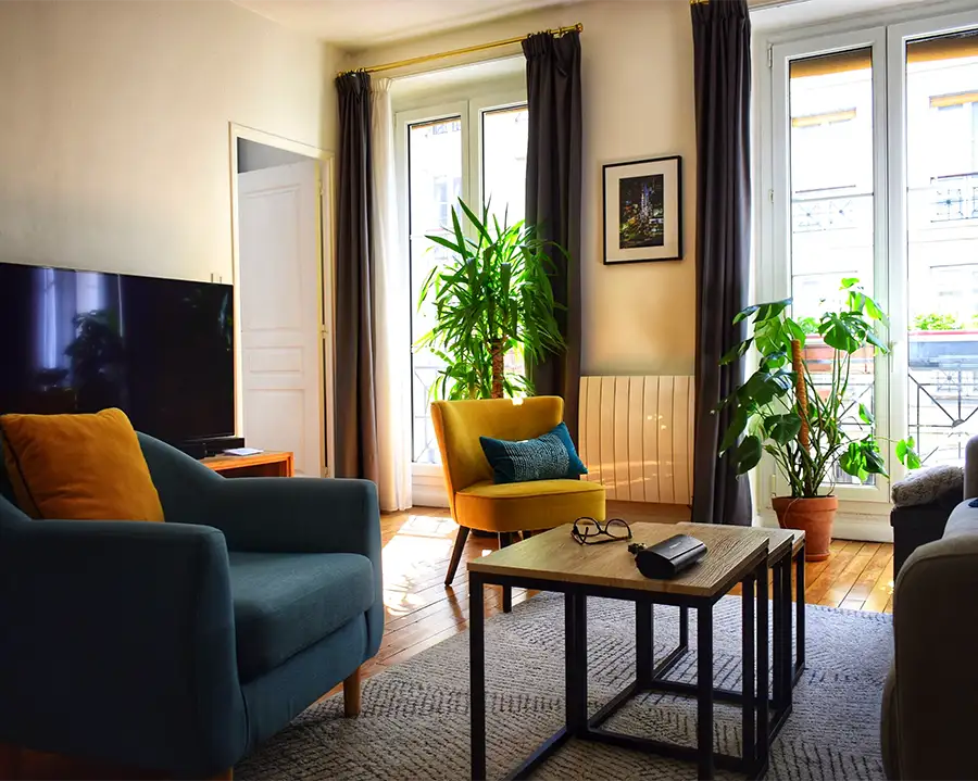 Stilvoll eingerichtetes, helles Wohnzimmer mit Sesseln und Zimmerpflanzen für Homestaging.
