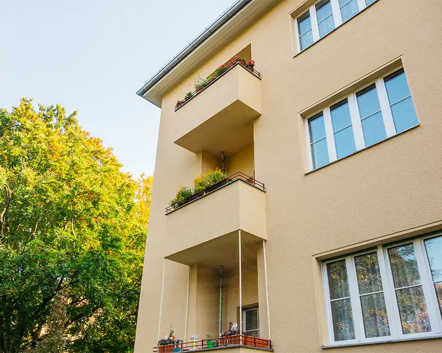 Außenansicht eines modernen Wohnhauses aus einer Froschperspektive vor blauem Himmel.